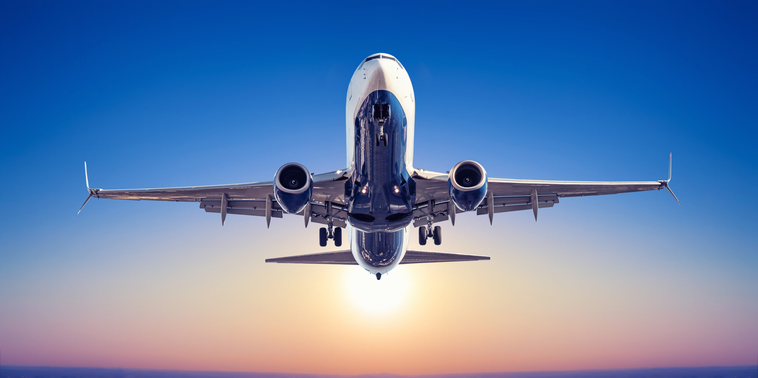 airplane taking off in sunset
